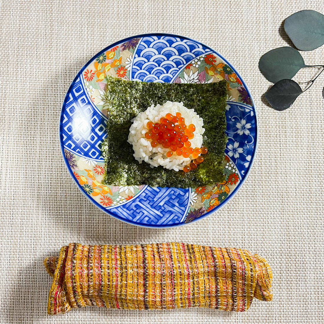 Rice with salmon roe and seaweed on decorative plate.