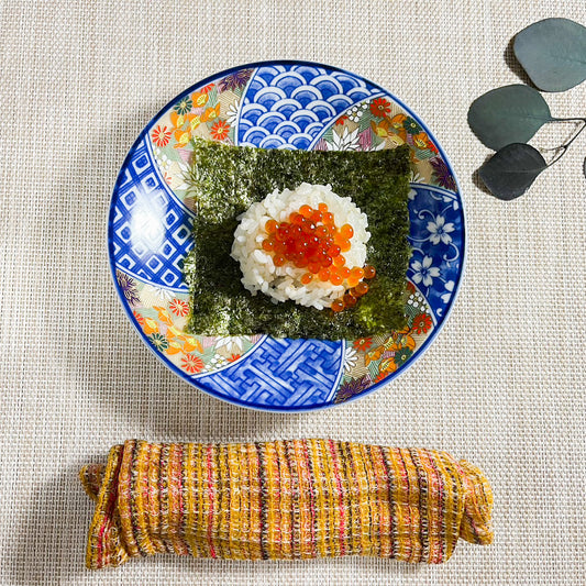 Rice with salmon roe and seaweed on decorative plate.