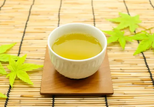 Green tea poured into a cup of hot water