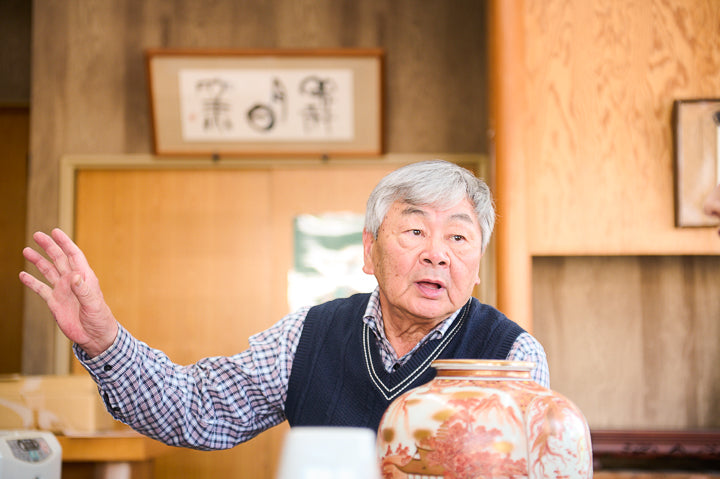 Mr. Yamada speaks with a vase with postage stamp decorations produced at the time in the background.